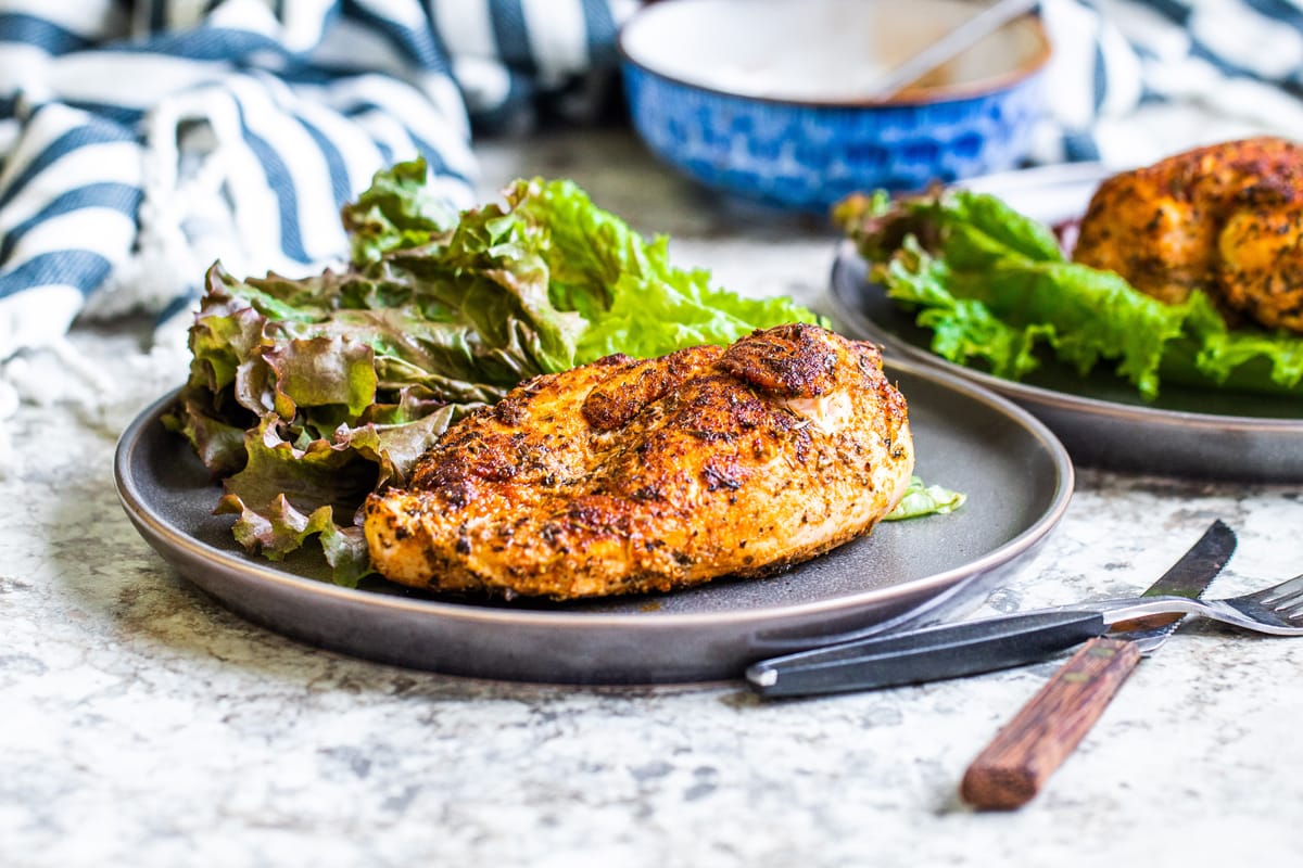 angled shot of blackened chicken on plate with lettuce