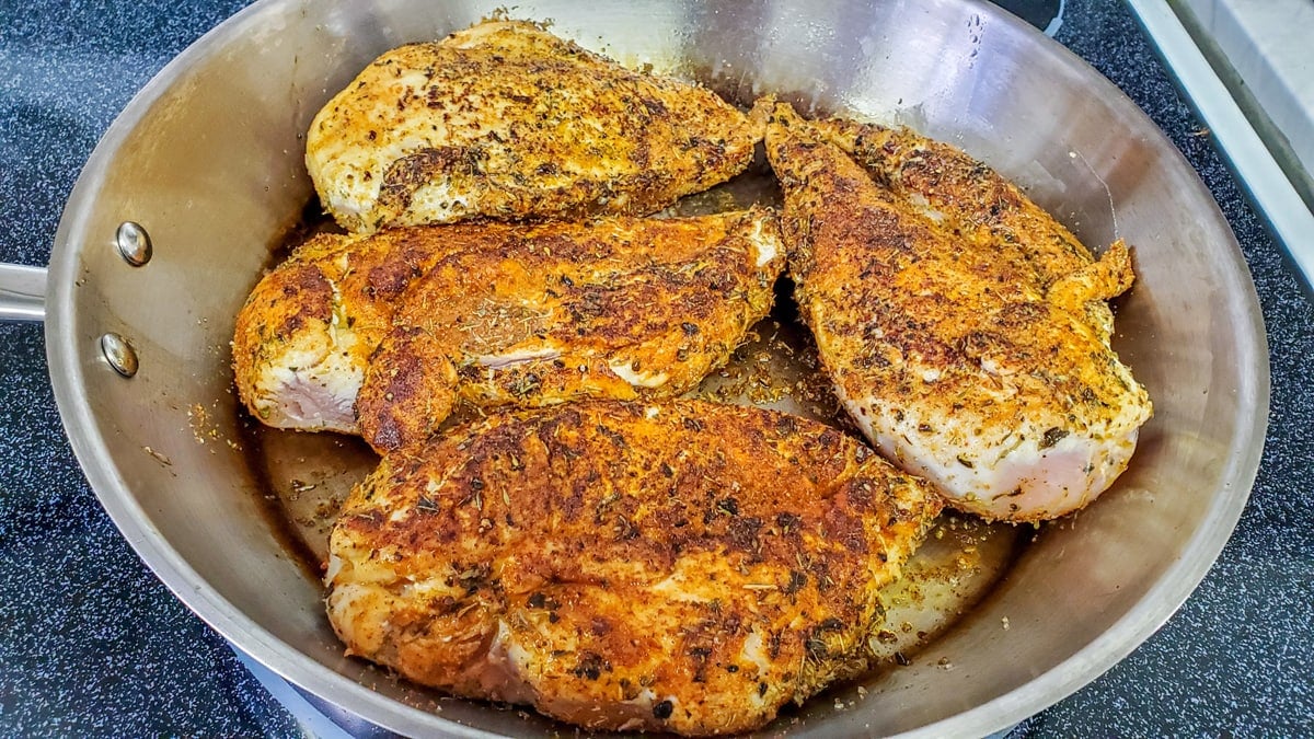 searing chicken in a skillet 
