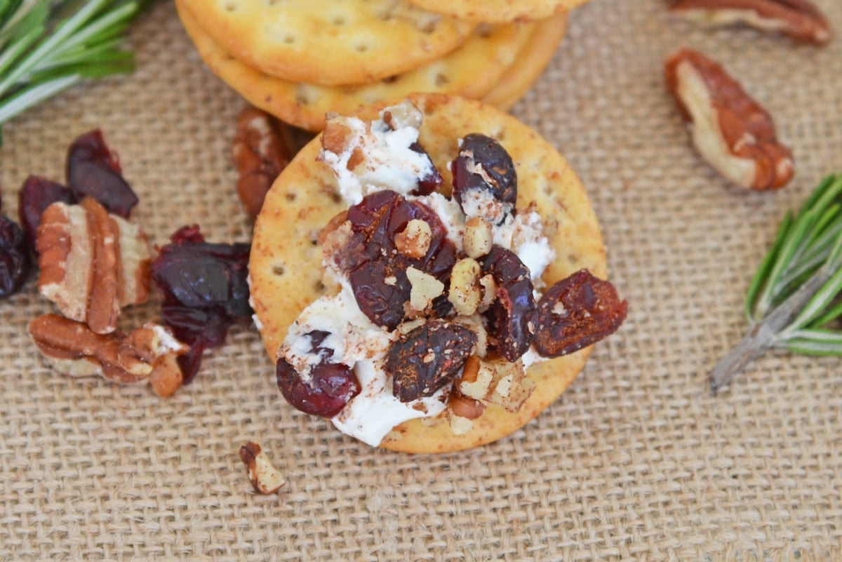 dried cranberries and pecans with goat cheese on a cracker 