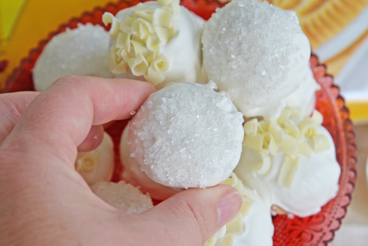 hand picking up a white chocolate oreo cookie ball 