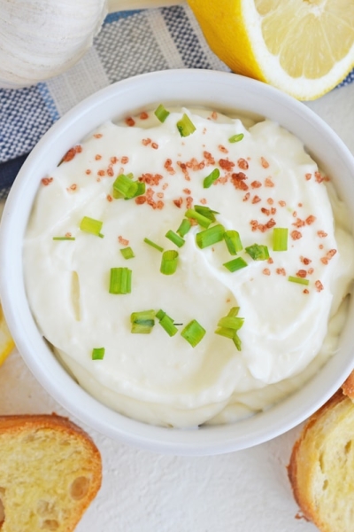 overhead bowl of garlic aioli with lemons and crostini