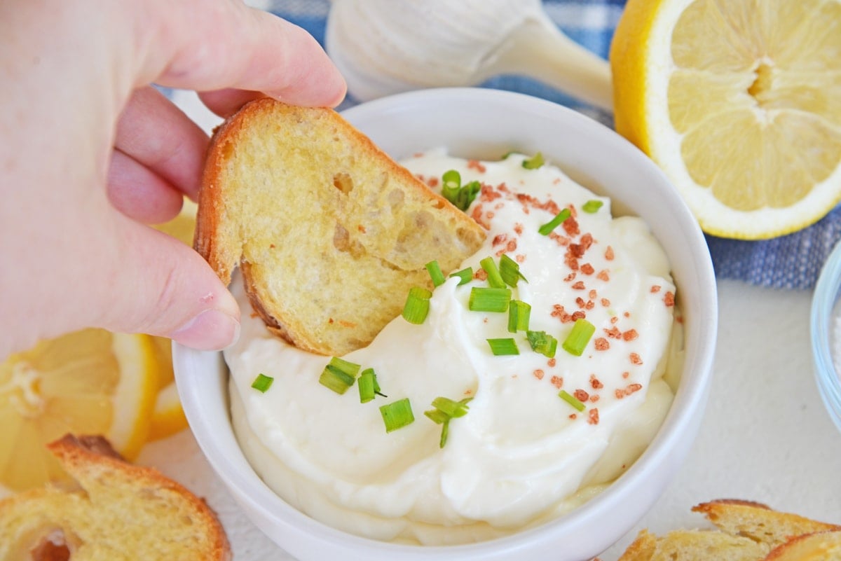crostini dipping into a bowl of homemade aioli 