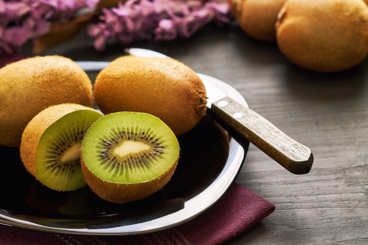 cut and whole kiwi on a plate 