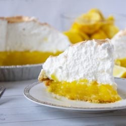 Slice of lemon meringue pie on a white plate
