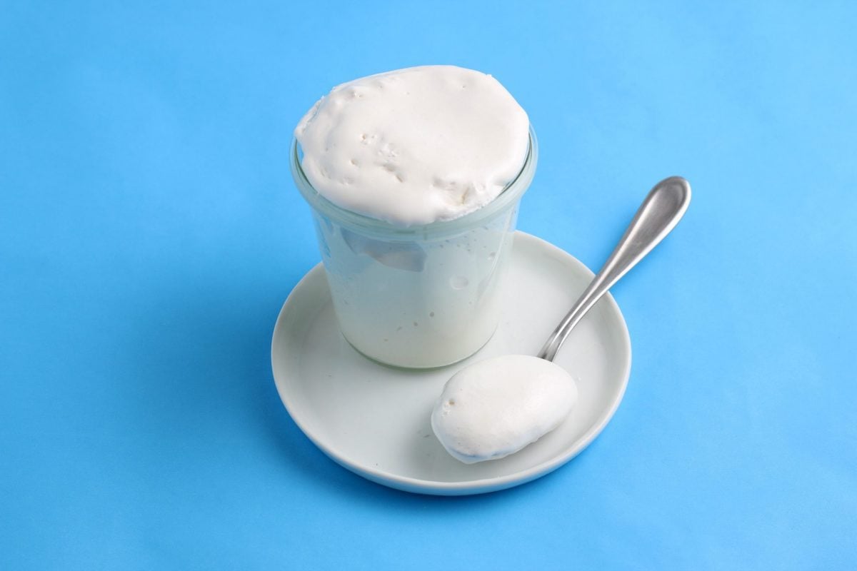 jar of marshmallow fluff on blue background 