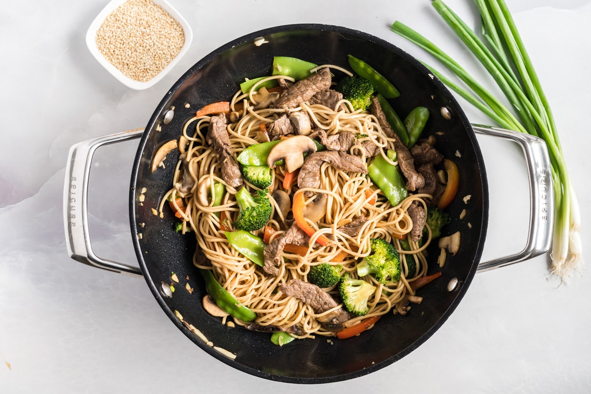 lo mein in a wok before garnishing 