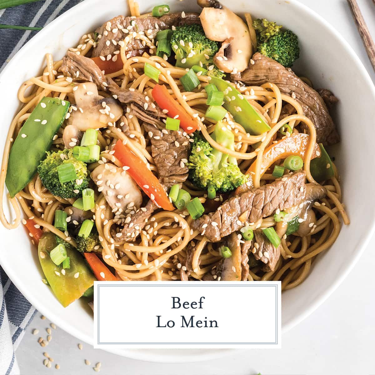 white bowl of lo mein garnished with scallions and sesame seeds