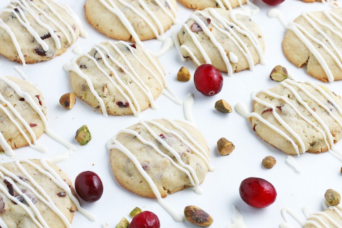 cookies drizzled with icing with fresh cranberries and pistachios