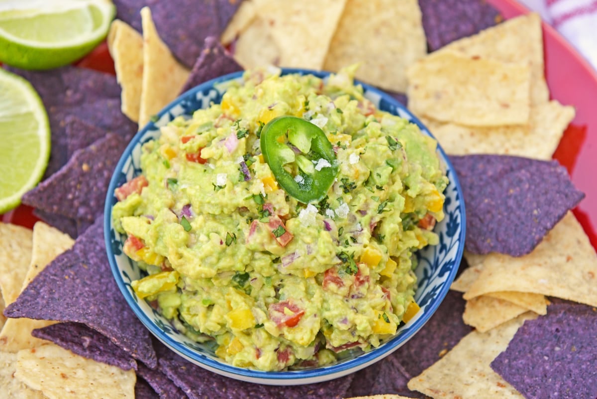 bowl of homemade guacamole surrounded by tortilla chips 