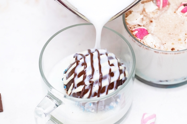 pouring milk over hot chocolate bombs