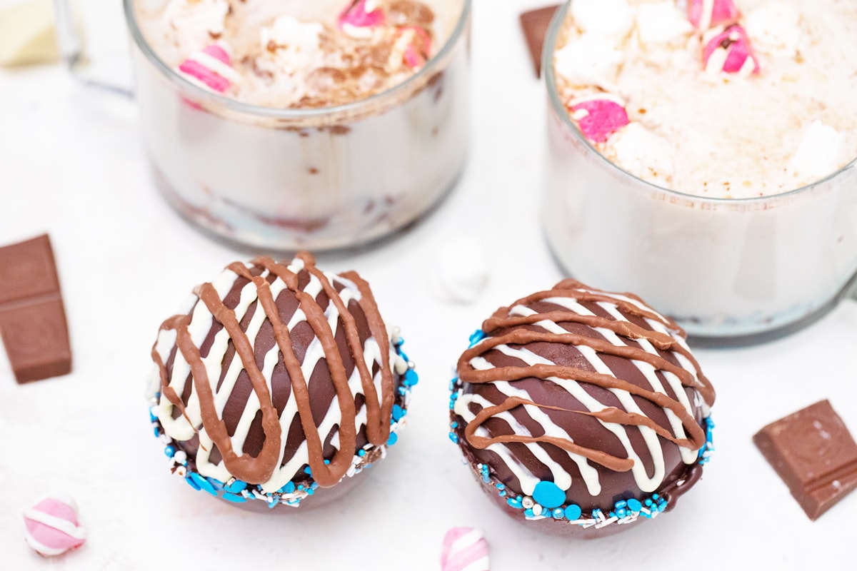 two hot chocolate bombs with blue sprinkles 