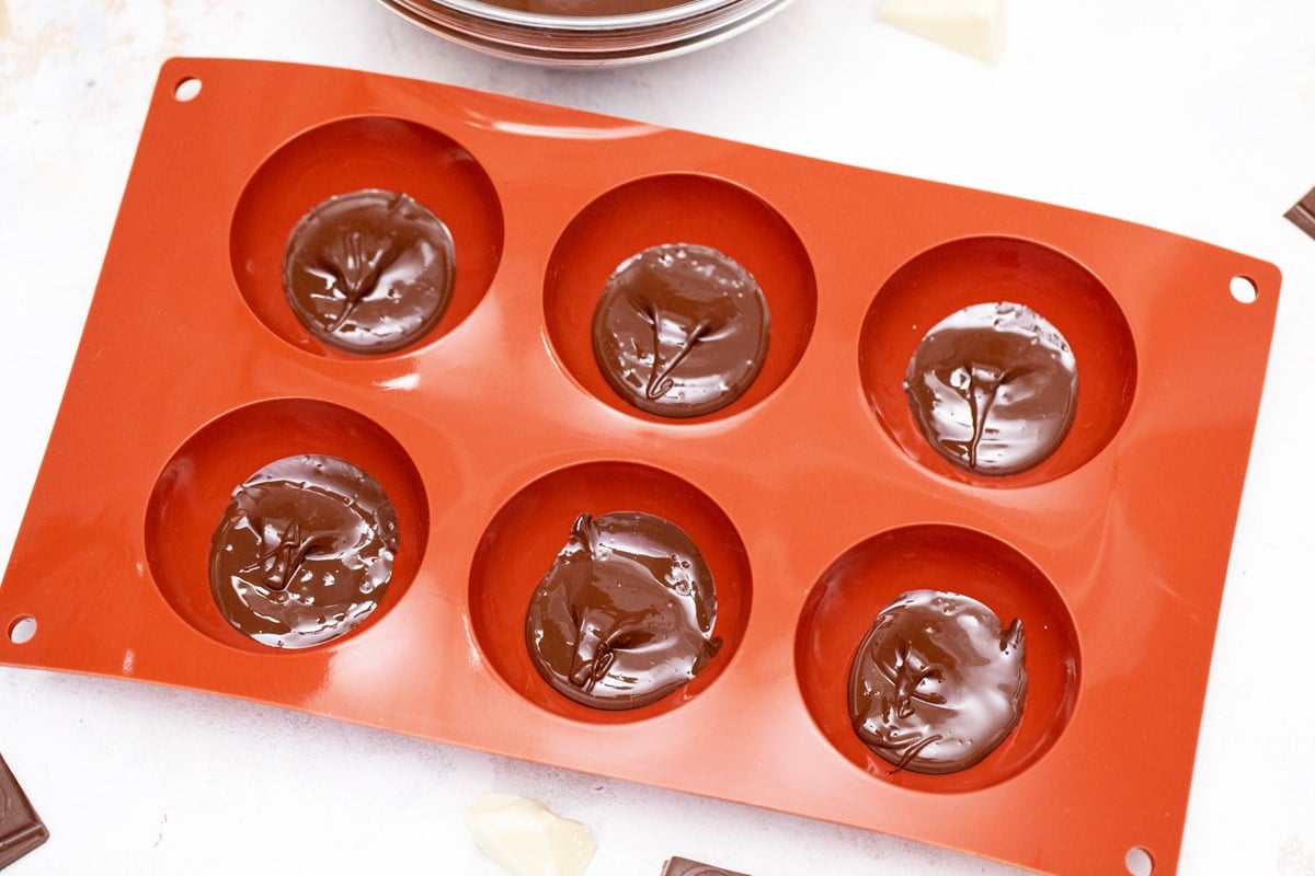 melted chocolate in a chocolate bomb mold 