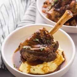 lamb shanks in a bowl with potatoes