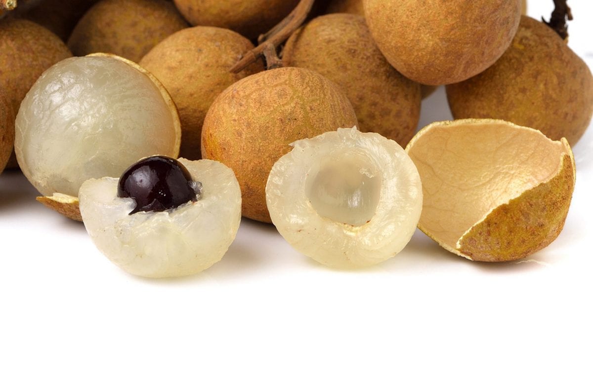 close up of longan fruit cut open with a pit  