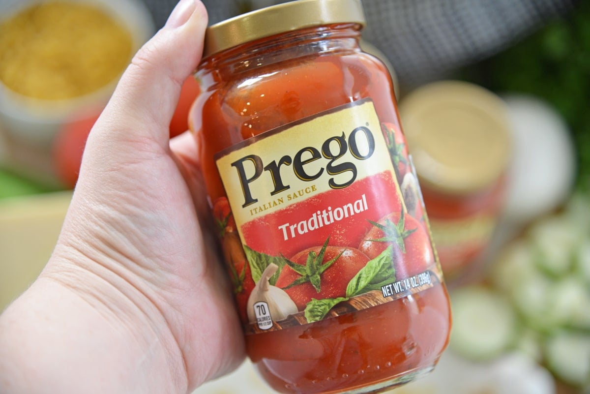 hand holding a jar of Prego Traditional Pasta Sauce 