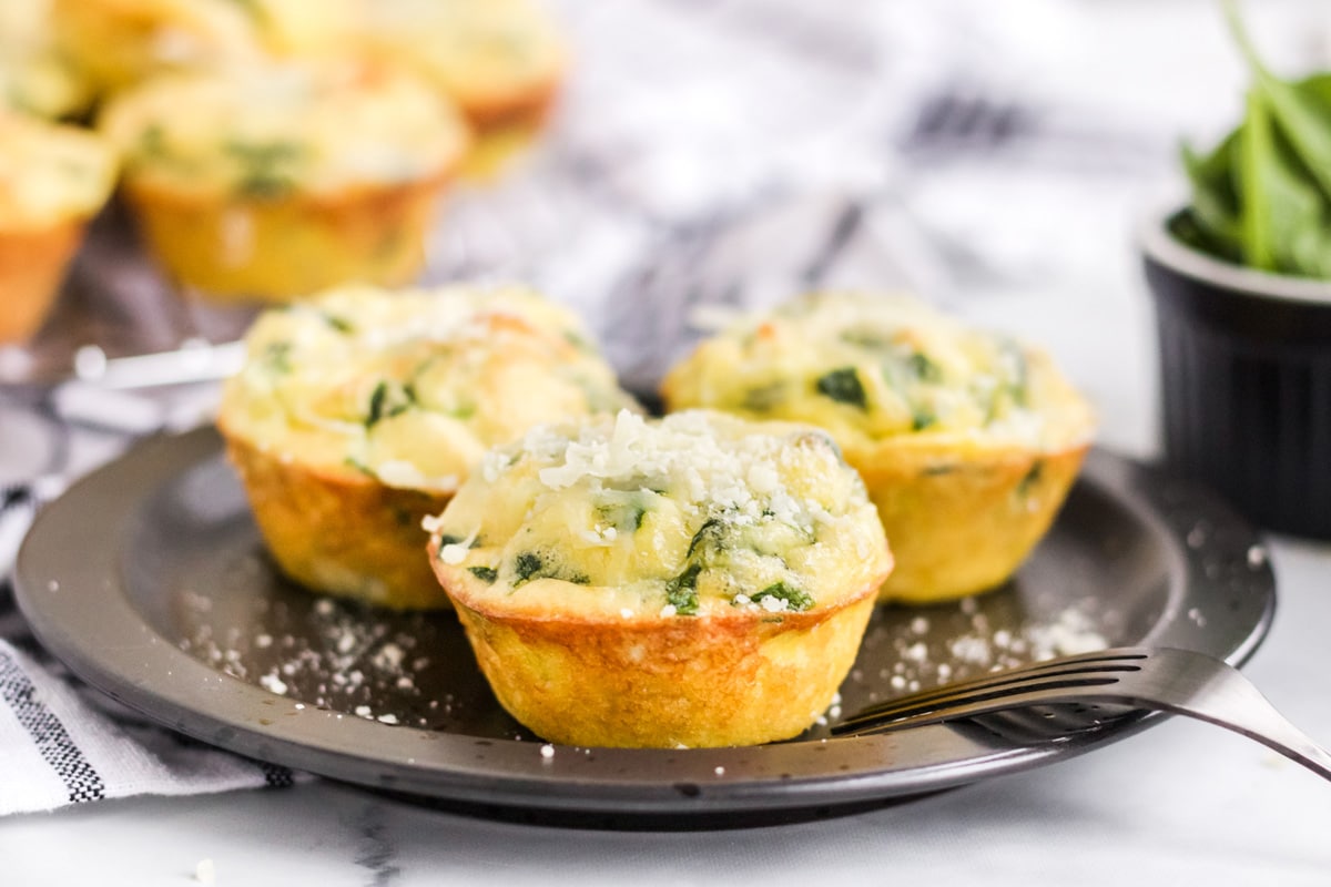 quiche florentine muffins on a black serving plate 