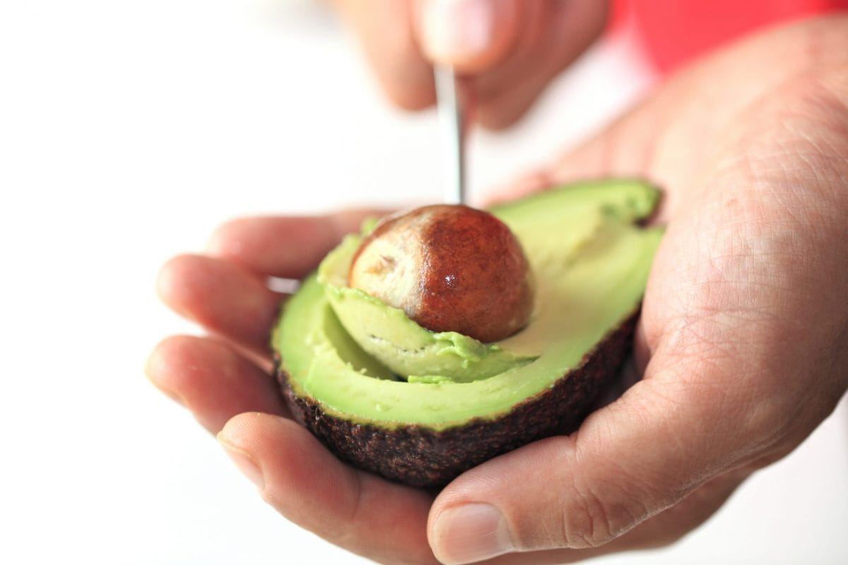 hand pitting an avocado 