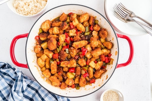 tossing chicken in sweet and sour sauce