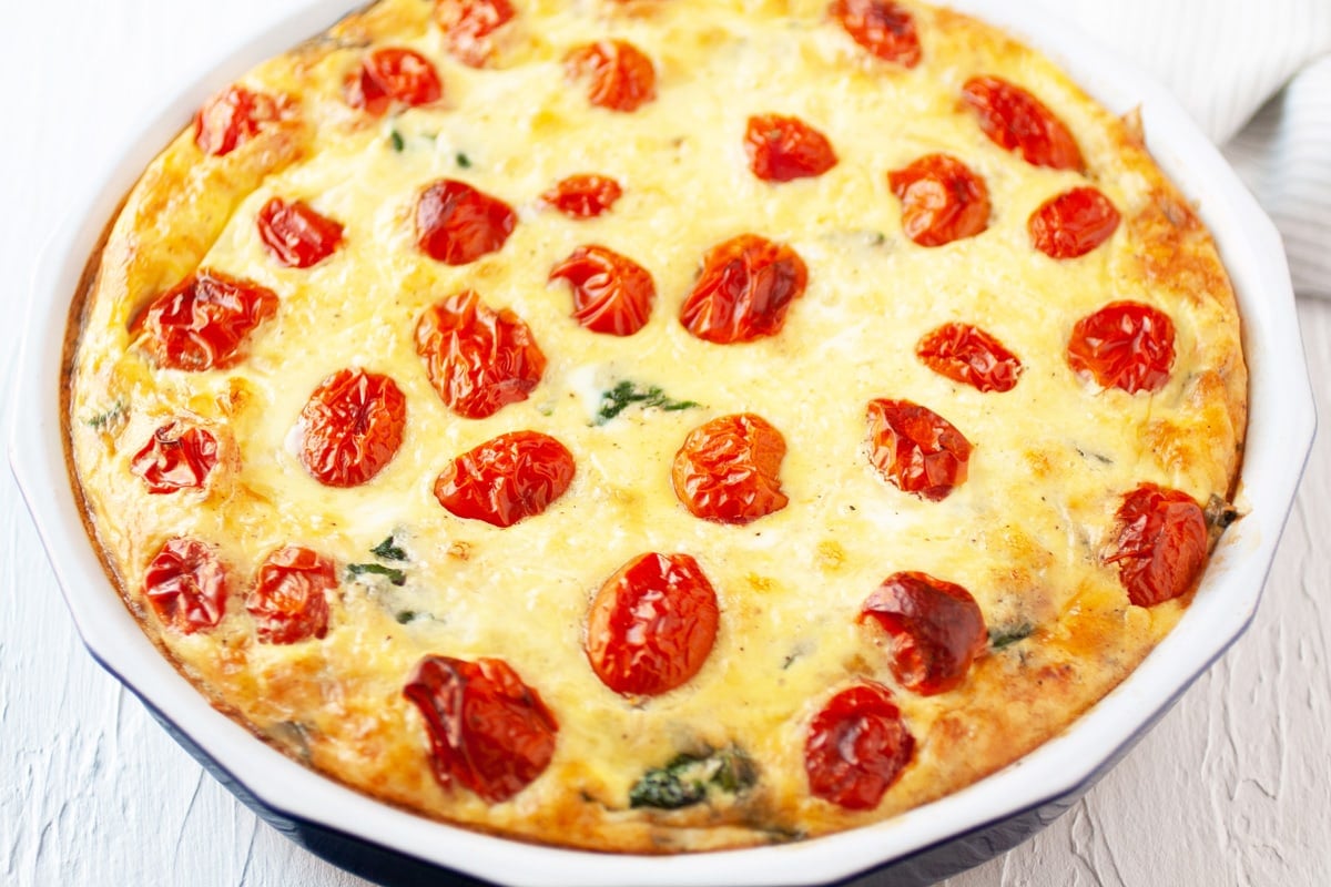 angle of quiche with tomato topping 