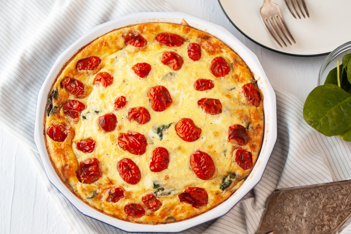 overhead of spinach quiche with tomato 