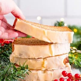 hand grabbing slice of eggnog bread