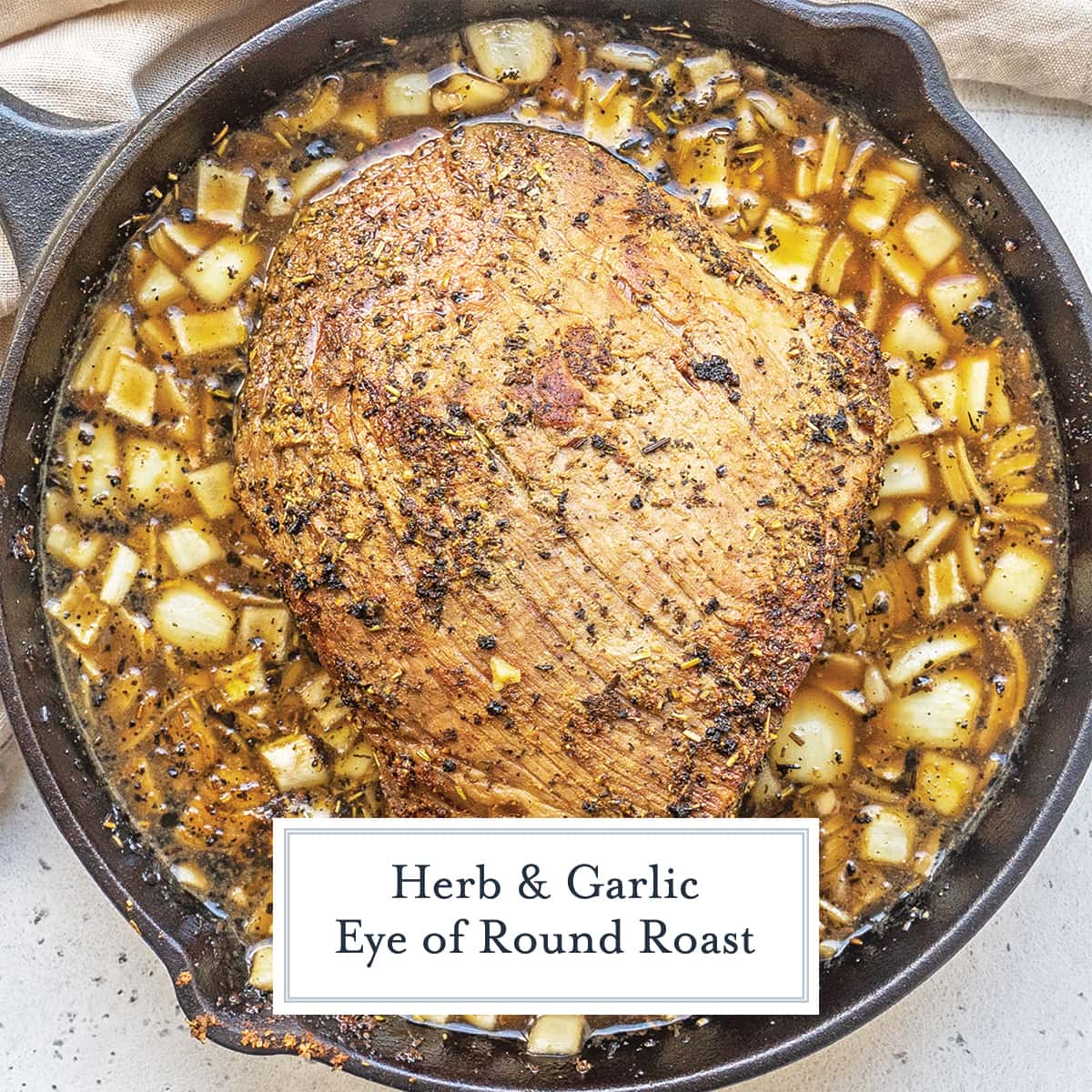 overhead of eye of round roast in cast iron with onions and broth