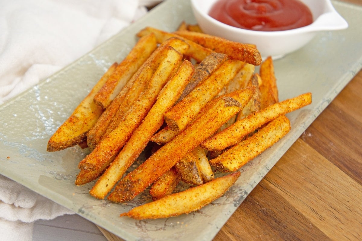 angle view of Cajun fries on a green platter 
