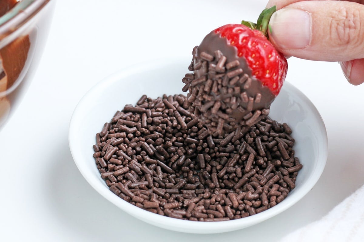 dipping strawberry in chocolate sprinkles (jimmies) 
