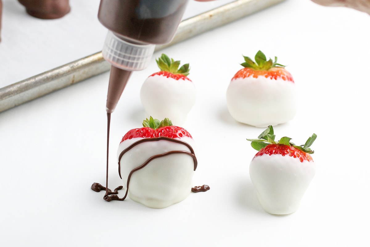 drizzling chocolate on white chocolate strawberry 