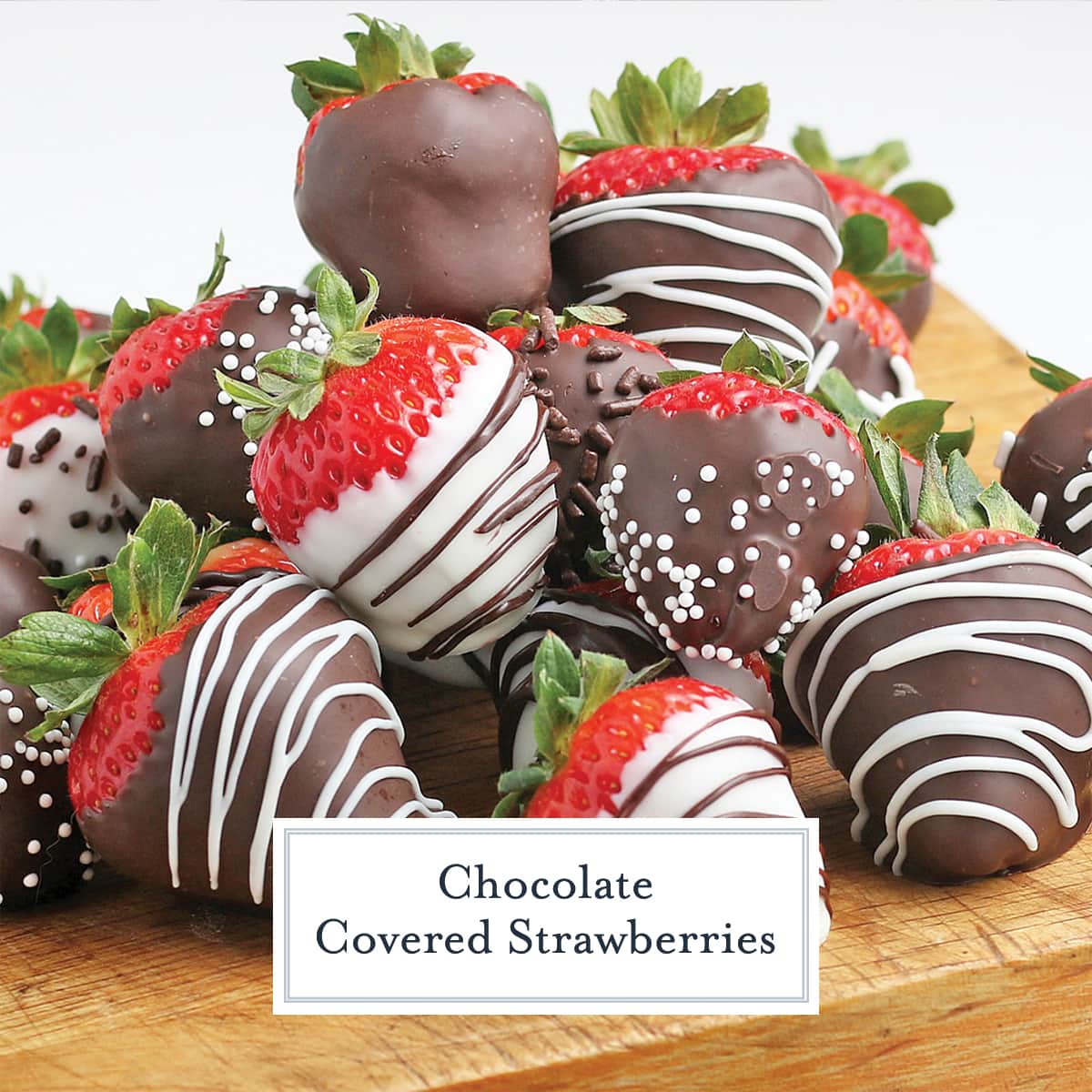 close up of chocolate covered strawberries on a wood cutting board 