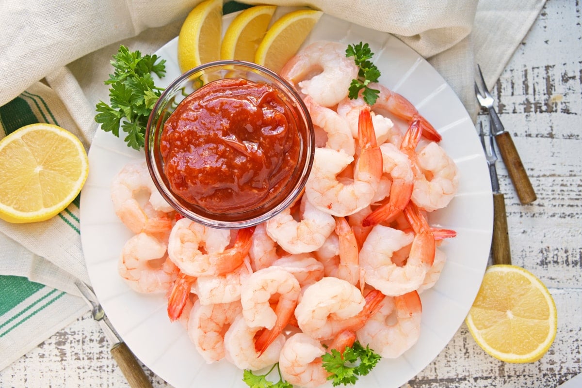 overhead of plate of shrimp with cocktail sauce 