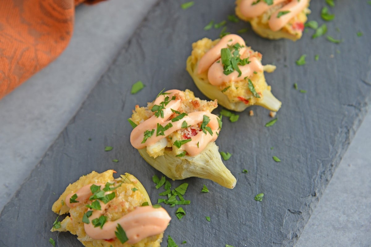 angled shot of tray of crab dip stuffed artichoke hearts