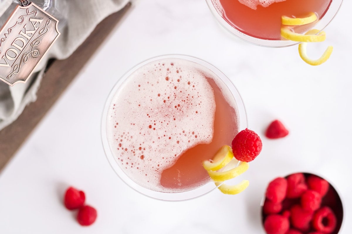 overhead of french martini garnished with a lemon twist and fresh raspberry 