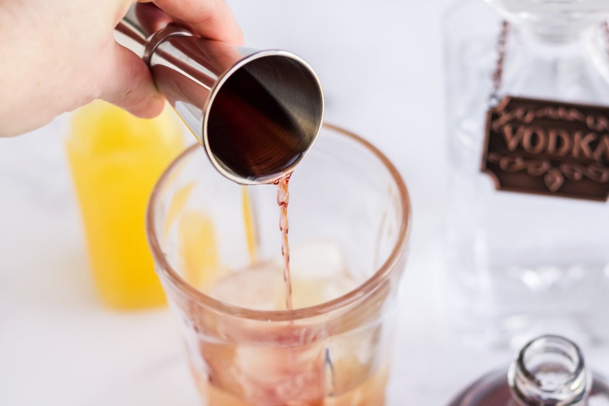 pouring chambord into a cocktail shaker 