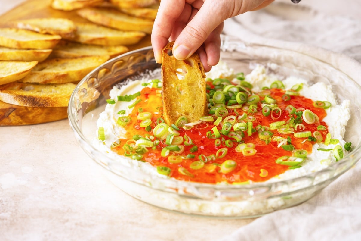 baked goat cheese dip with a buttery crostini dipping in 