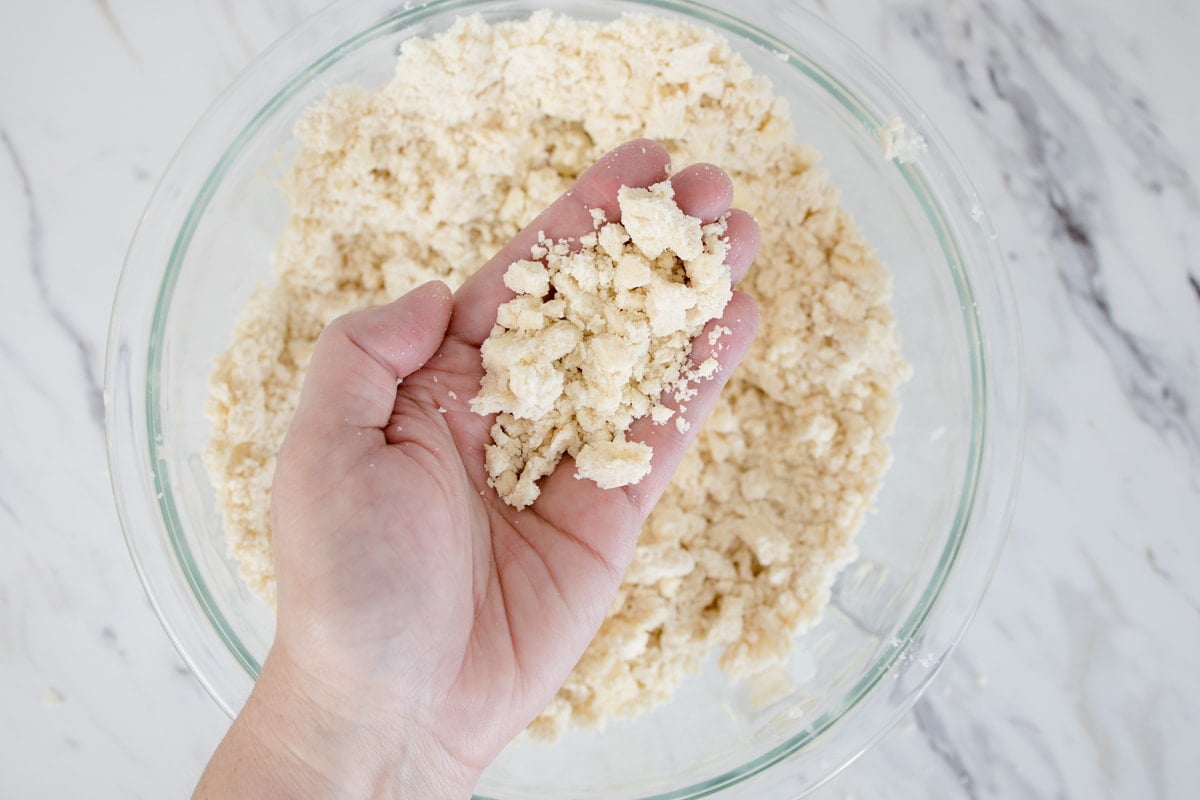 crumbled pieces of pie crust dough in a hand 