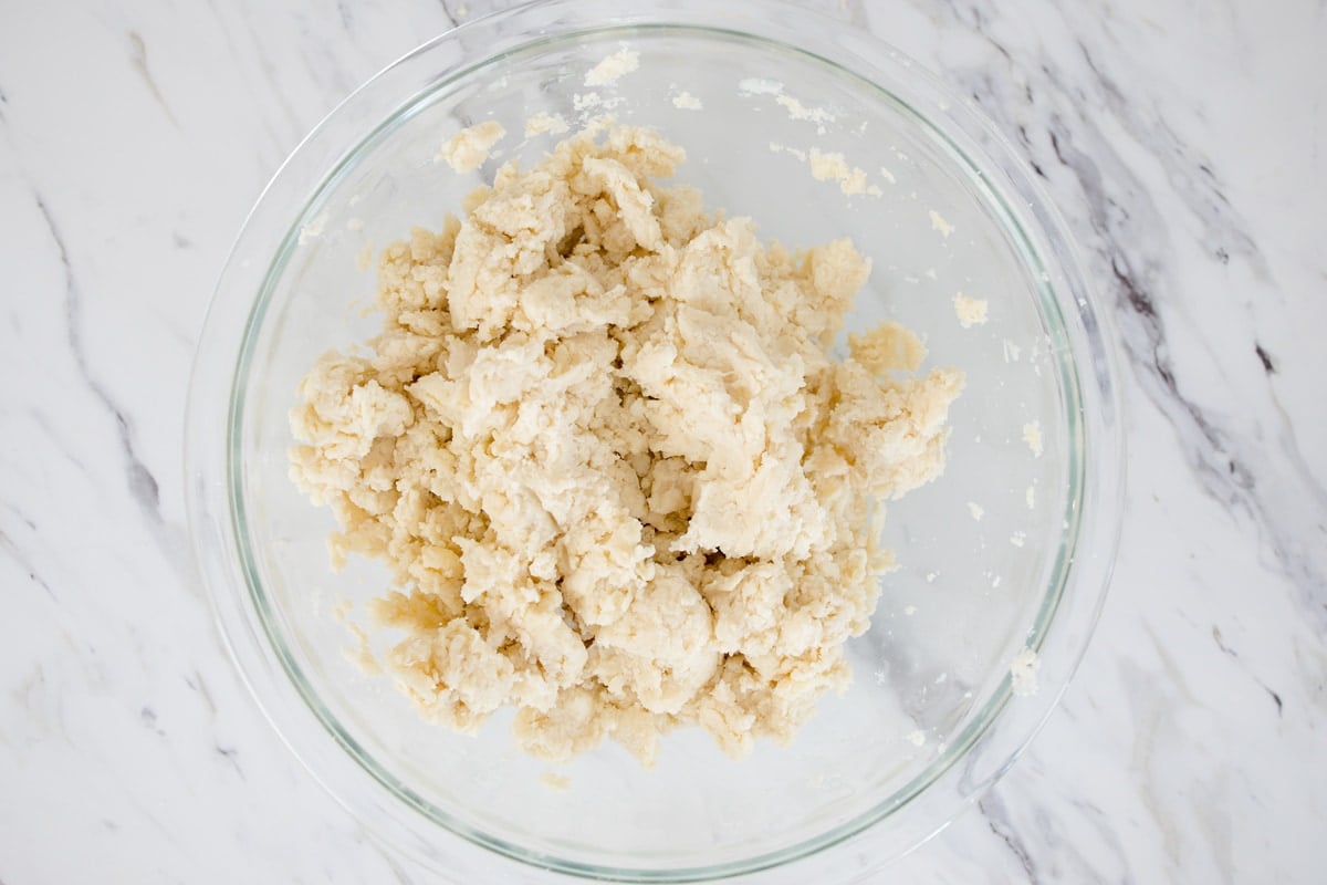 homemade pie crust dough in a glass mixing bowl 