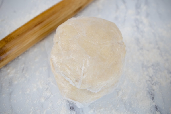 two pie crusts wrapped in plastic wrap