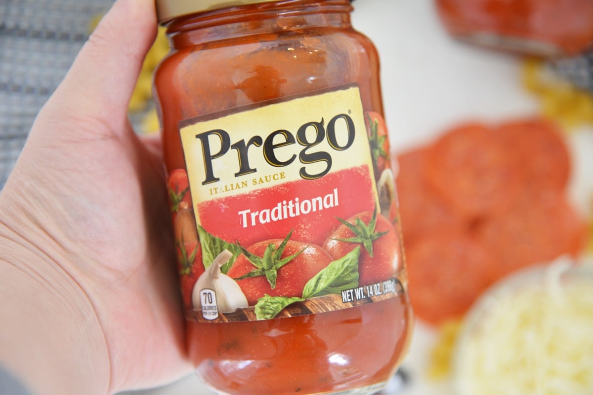 hand holding a jar of prego  