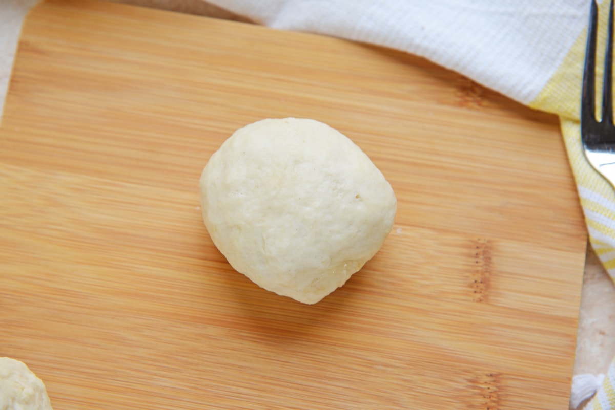 ball of raw dough on cutting board