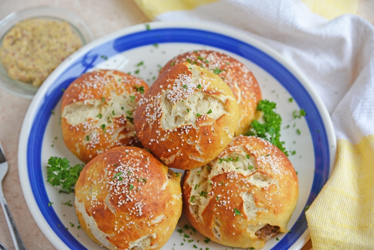 angled shot of plate of pulled pork stuffed pretzel rolls