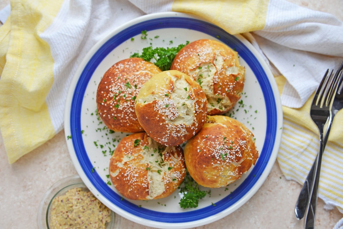 overhead shot of stack of pulled pork stuffed pretzel rolls on a plate