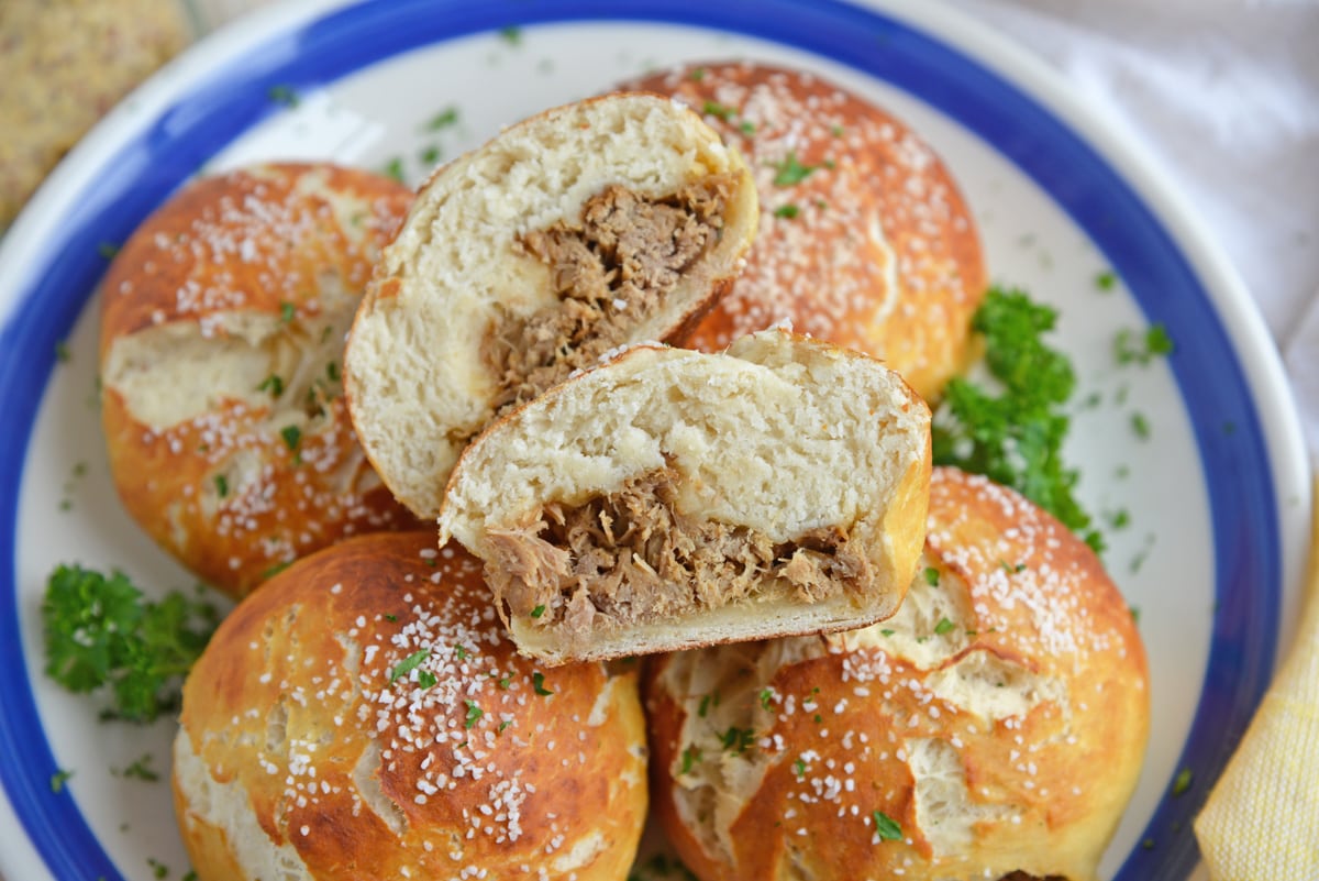 overhead shot of pulled pork stuffed pretzel roll cut in half