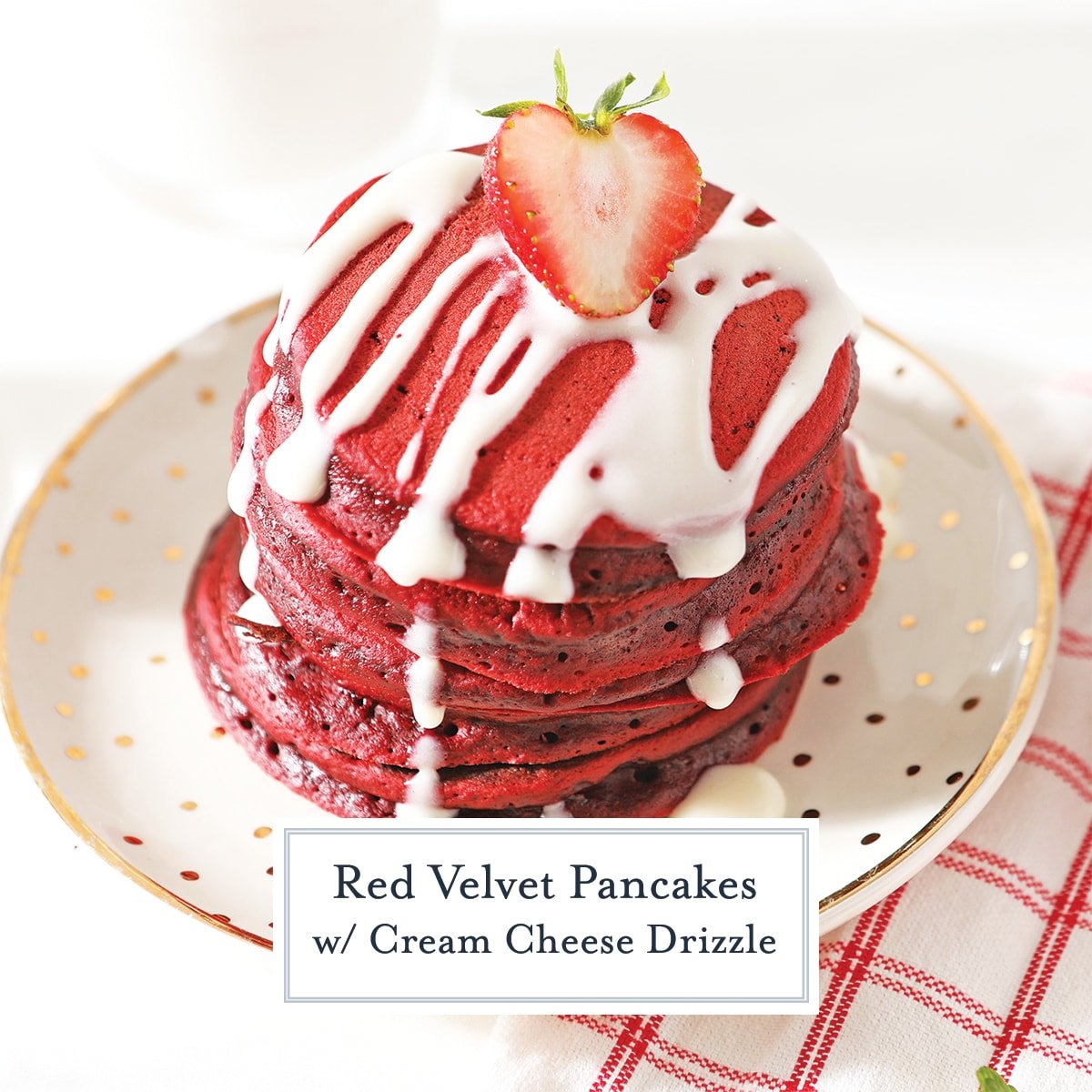 angle view of red velvet pancakes with cream cheese drizzle and fresh strawberry halve 