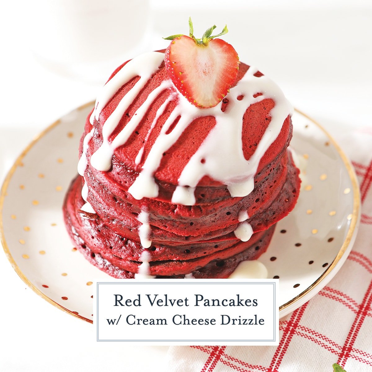 angle view of red velvet pancakes with cream cheese drizzle and fresh strawberry halve