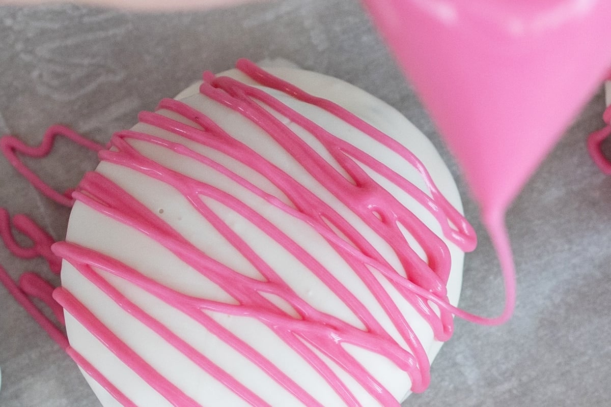 decorating cookies drizzled with pink chocolate 