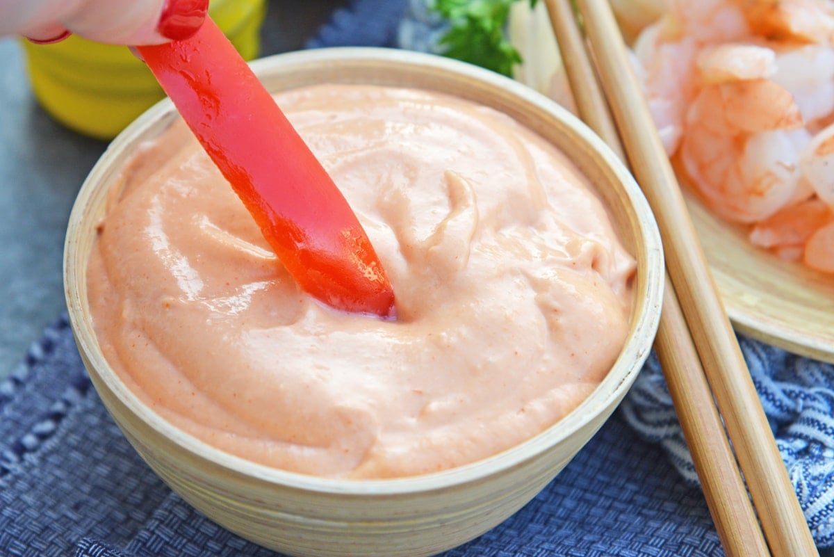 red pepper strip dipping into pink sauce 