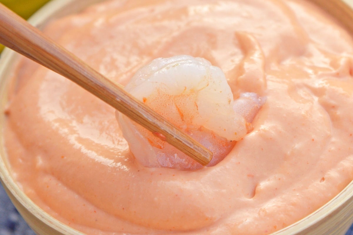 shrimp with chopsticks dipping into sauce 