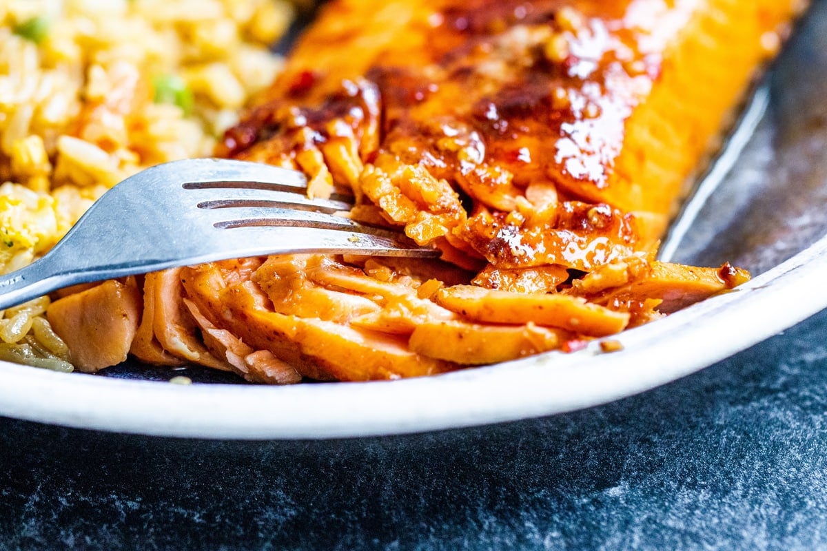 close up of fork digging into a piece of salmon 