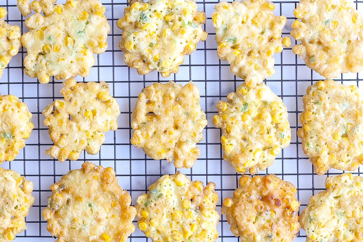 corn fritters on a wire rack draining 